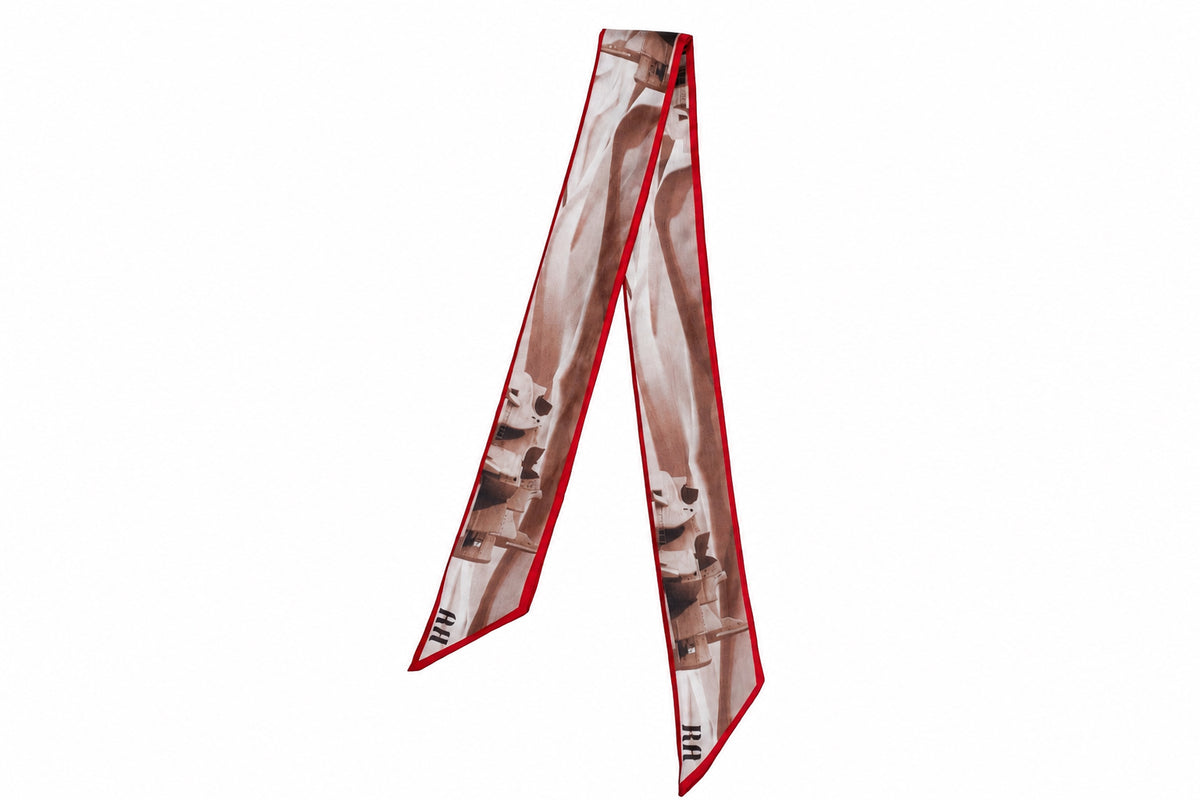 A long rectangular scarf with a brown and beige abstract print and a red border, displayed on a plain white background.